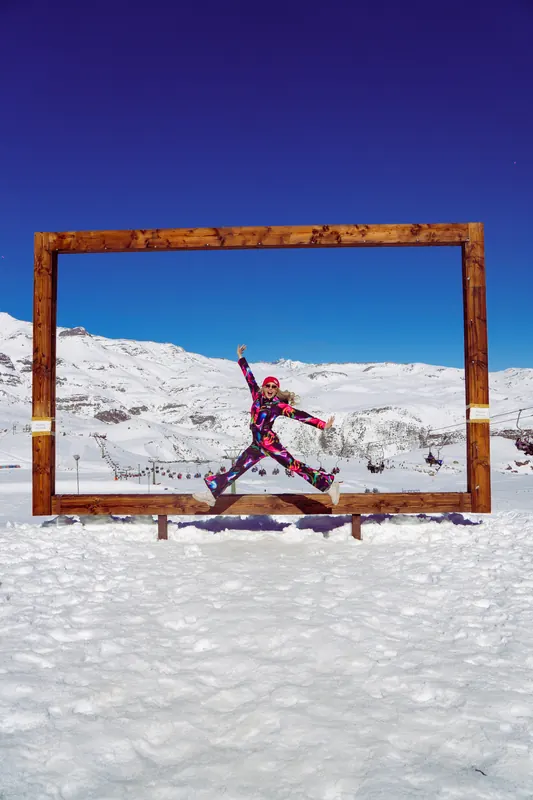 Laise jumping inside a giant wooden frame on the snow