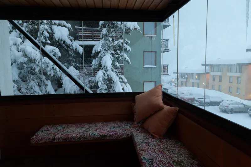 Cushioned window seat looking out on a snowy forest
